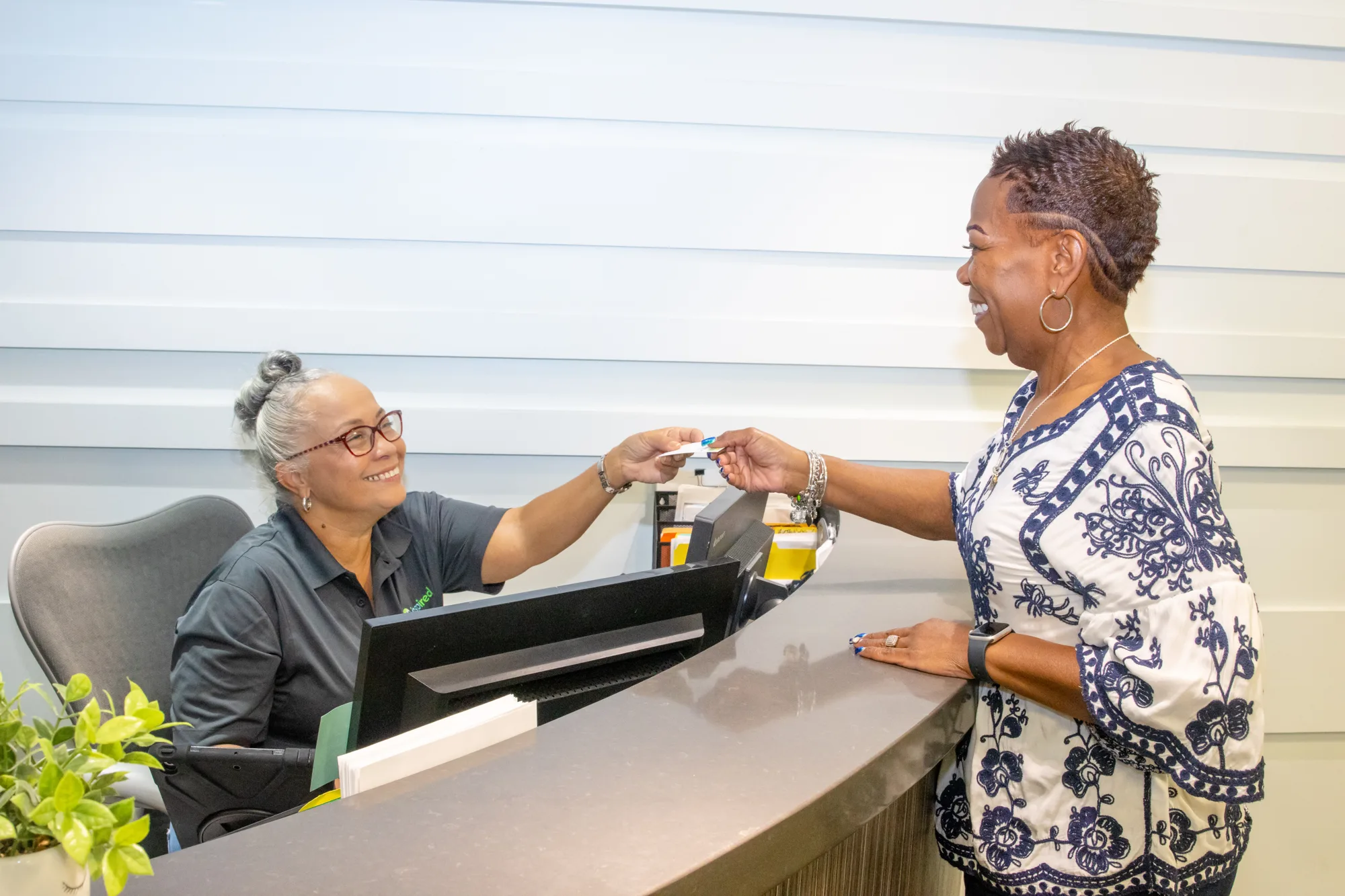 Front desk staff helping a patient at OIC Inspired